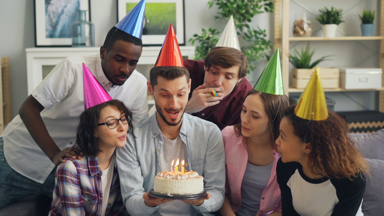 Friends celebrating a birthday with a cake and candles