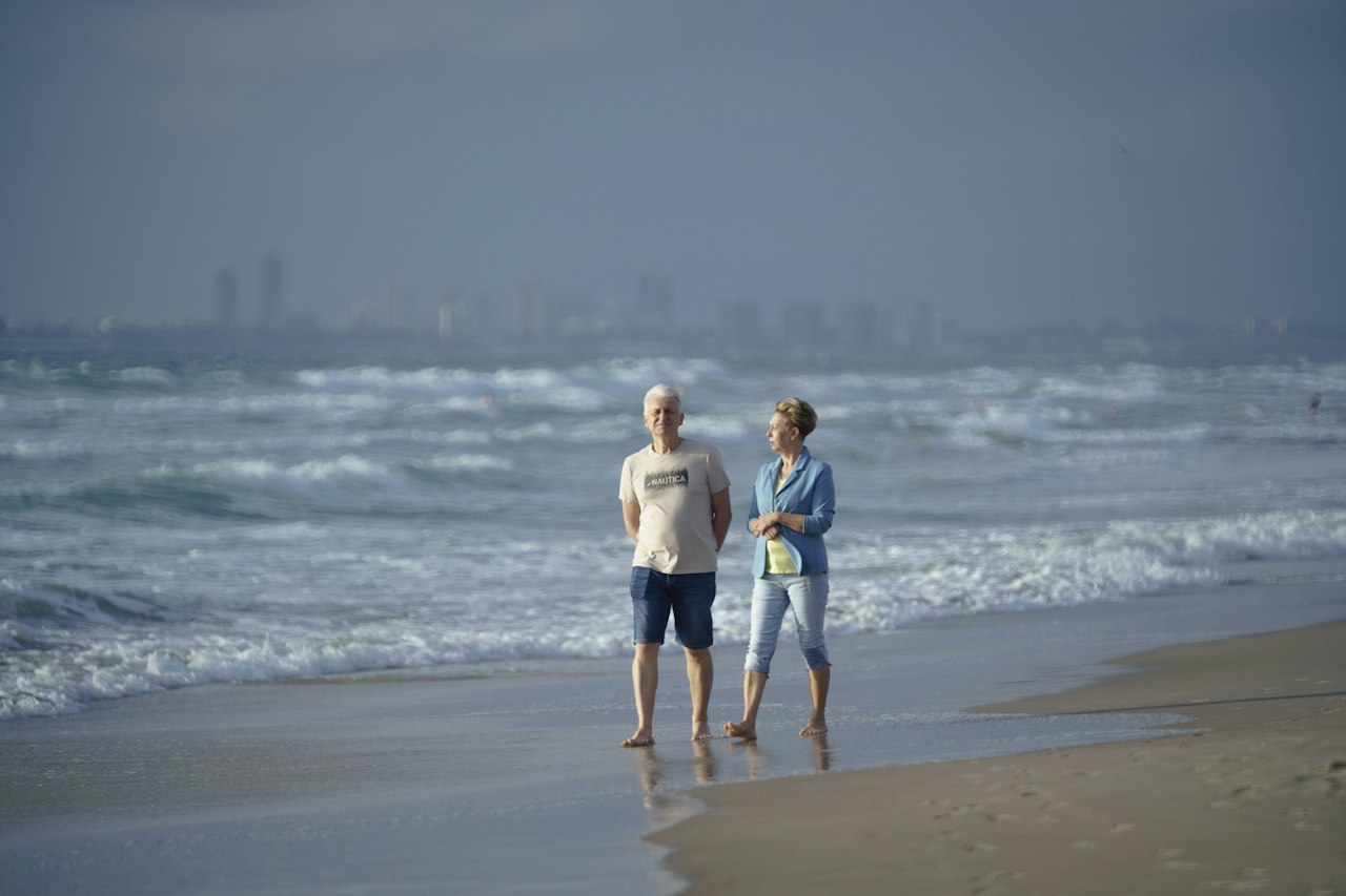 Retired couple standing on a beach